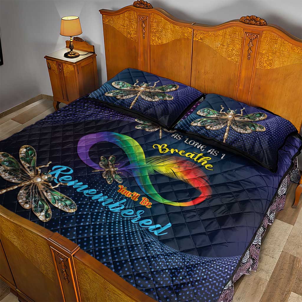 Quilt bed set with dark navy quilt, large dragonfly artwork, and rainbow heart on pillows