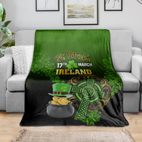 St. Patrick's Day blanket draped over sofa, green/black Ireland text, shamrock and pot of gold