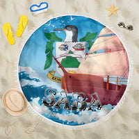 Circular Saba beach blanket in blue with sailboat and ocean print, fringed white edge.