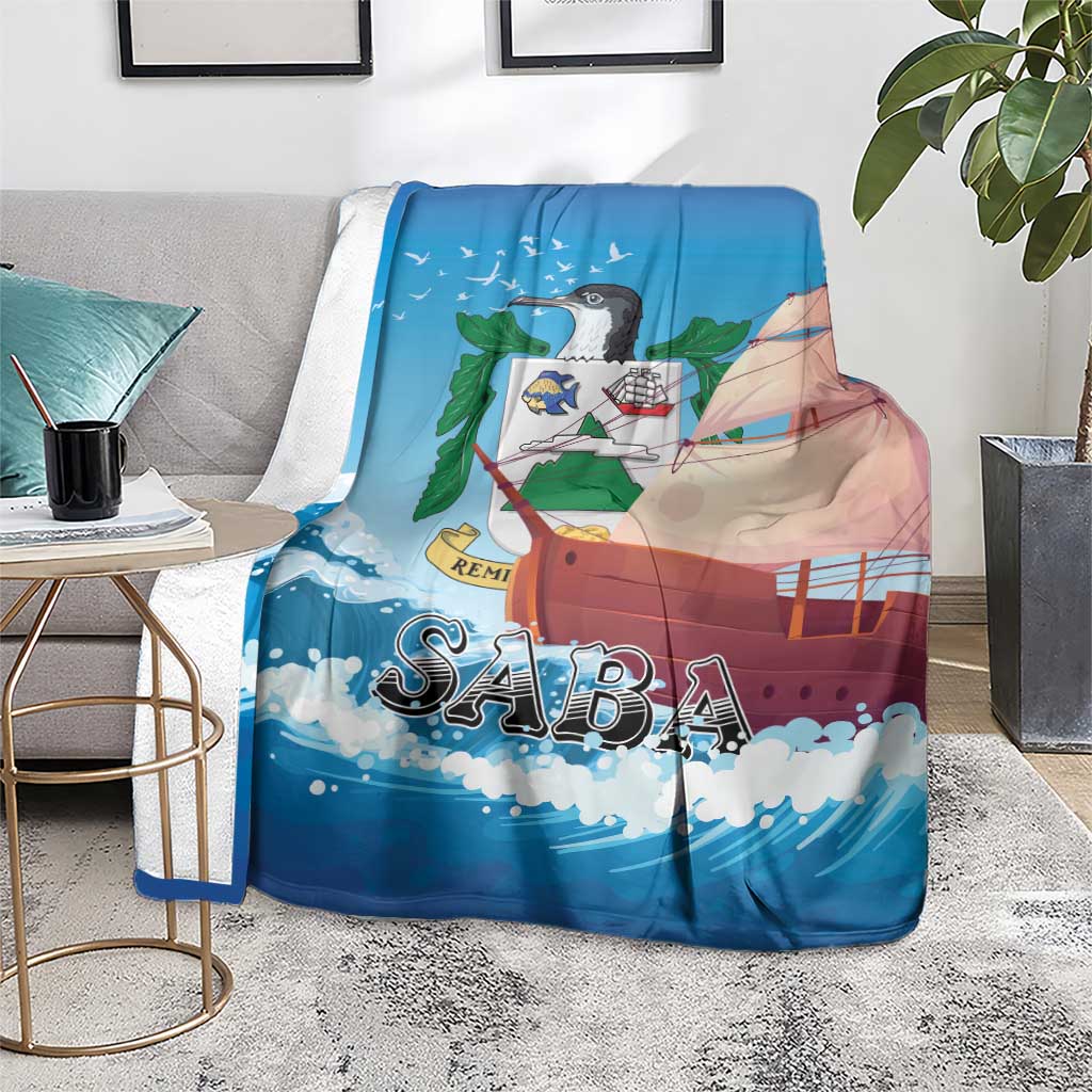 Blue SABA sailboat blanket as a throw, displayed on a gray sofa seat