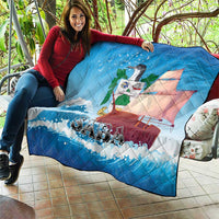 Blue quilt blanket laid over a couch with sailboat, waves, bird, and “SABA” text