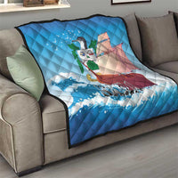 Blue quilt blanket on a living room sofa with sailboat, ocean waves, and “SABA”