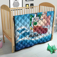 Blue quilt blanket on a child bed with sailboat and waves, “SABA” lettering