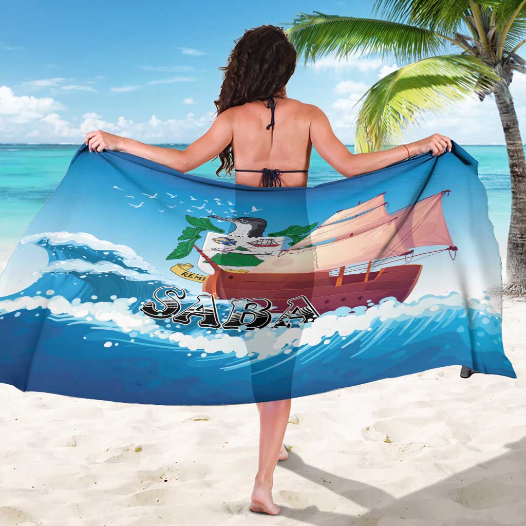 Blue sarong with sailboat print and SABA logo, draped across shoulders