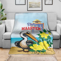 Blue and tan throw blanket with pelican and yellow flowers on a couch