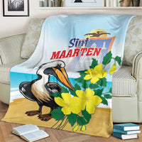 Light blue and tan blanket with pelican and yellow flowers, shown draped on a sofa