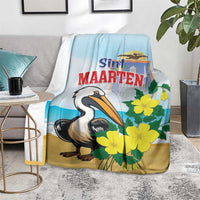 Blue and tan blanket with pelican and yellow flowers, resting on a gray chair