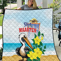 Light blue and tan quilt blanket with diamond stitching, pelican graphic, yellow flowers