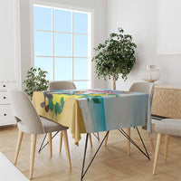 Blue tablecloth with pelican and yellow floral print, draped on dining table.