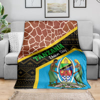Giraffe-pattern throw blanket with blue emblem, yellow trim, and black geometric stripe
