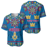 Two blue baseball jerseys with folk floral pattern: one “SWEDEN”, one “YOUR TEXT”.