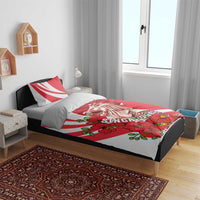 Red and white bedding set on a bed; merlion graphic with red orchid flowers