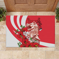 Red rubber doormat with white wave stripes, merlion statue, and red orchid flowers