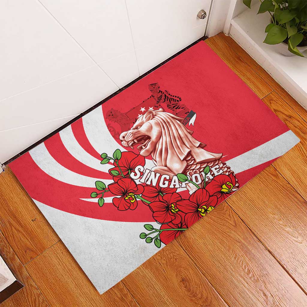 Red rubber doormat on wood floor with merlion graphic, white stripes, and flowers