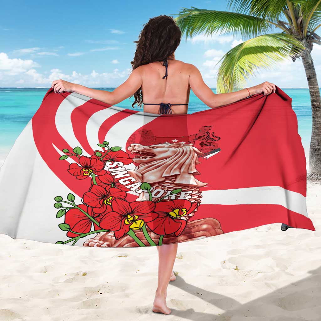 Red and white sarong spread out, showing merlion and lion face with orchid flowers