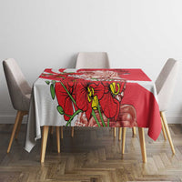 Red tablecloth on dining table with Merlion and red orchid floral graphic, white trim.