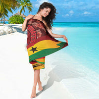Maroon tropical sarong with leaf print and Ghana flag colors, draped around waist