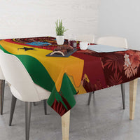 Red patterned tablecloth with green and yellow geometric bands and floral accents on dining table.