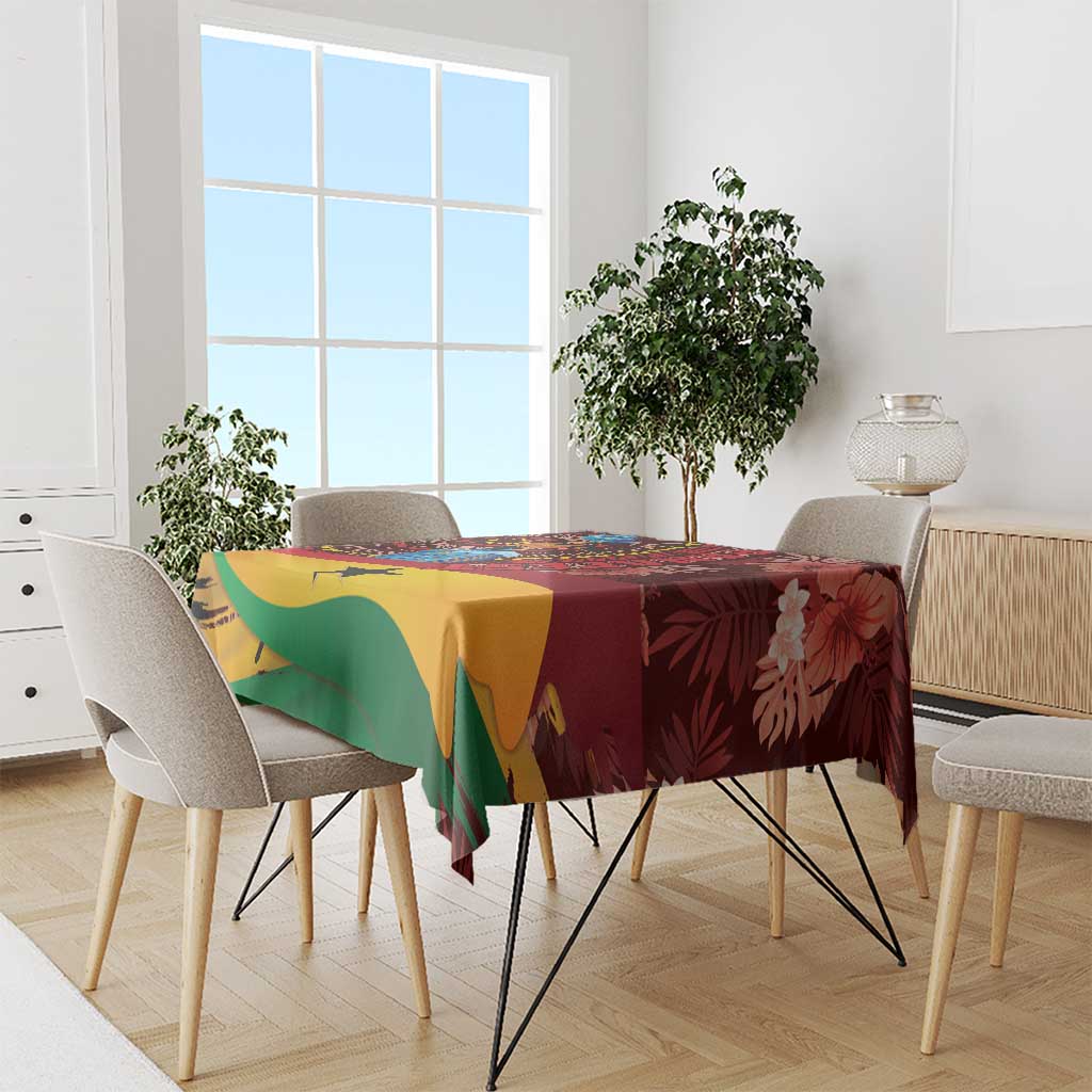 Red tablecloth with tropical Ghana design, green and yellow panels, on a long dining table.