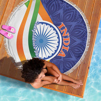 Round beach blanket with colorful diagonal stripes and blue-white emblem, fringed border