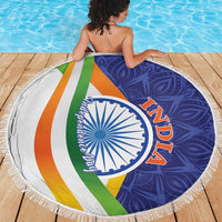 Round fringed beach blanket with colorful diagonal stripes and blue-white emblem, circular design