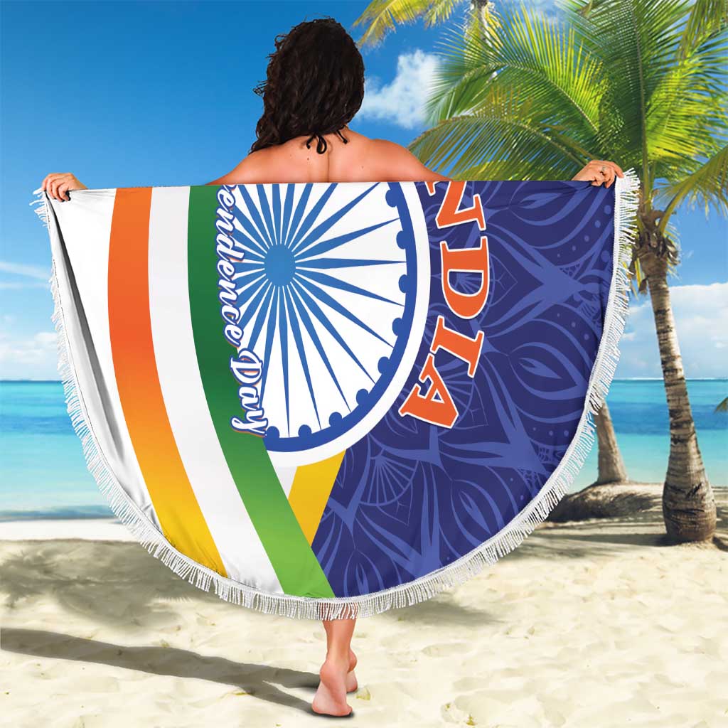 Round beach blanket featuring tri-color diagonal stripes, blue paisley emblem, and white fringe