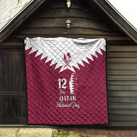 Red quilt blanket with white Qatar map emblem and “12 Qatar National Day” text