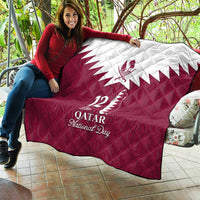 Red and white quilt blanket with white Qatar emblem, 12 De Qatar, and National Day lettering