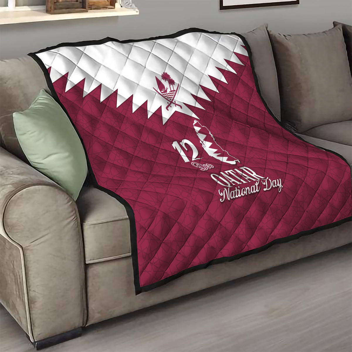 Red quilt blanket on sofa with white Qatar emblem and “12 Qatar National Day” text