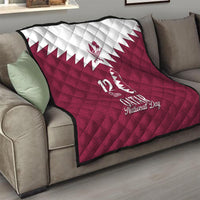 Red quilt blanket on sofa with white Qatar emblem and “12 Qatar National Day” text