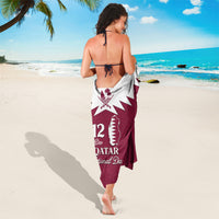 Maroon and white sarong with Qatar map emblem and 12 Qatar National Day lettering