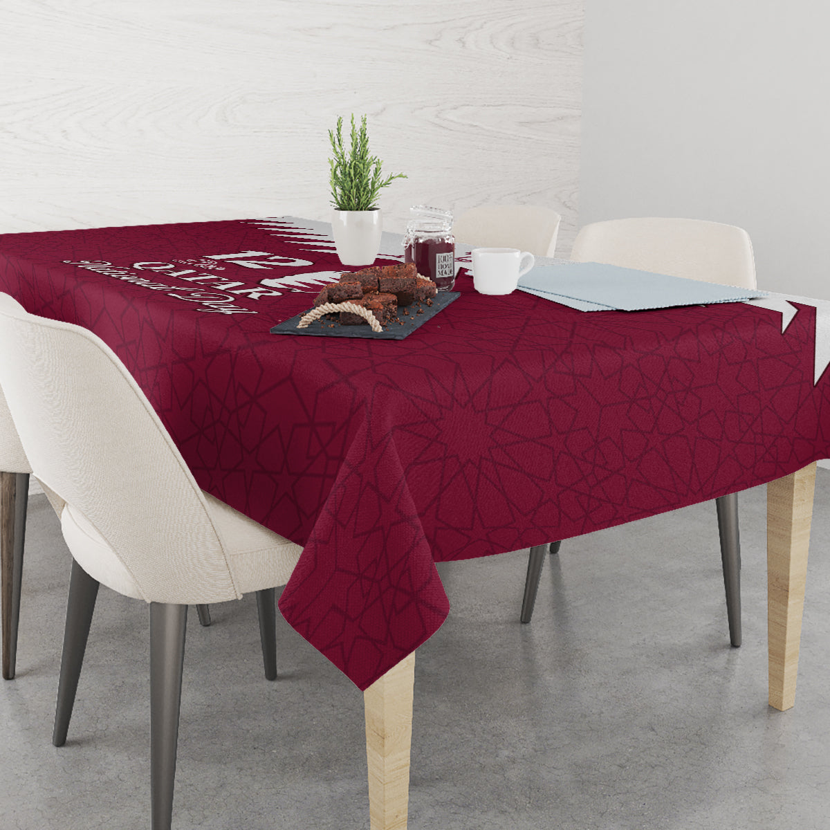 Red tablecloth with Qatar emblem and Islamic pattern print across the tabletop.
