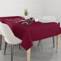 Red tablecloth with Qatar emblem and Islamic pattern print across the tabletop.