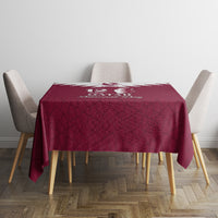 Red square tablecloth with Qatar map-and-emblem print and textured Islamic motif background.