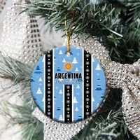 Blue circle Argentina Feliz Navidad ornament on a tree, striped with gold sun and snowflake dots.