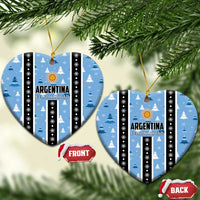 Blue heart-shaped Argentina Feliz Navidad ornaments hanging, striped with gold sun and snow trees.