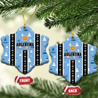 Blue mitten/gauntlet-shaped Argentina Feliz Navidad ornaments hanging, striped with gold sun.