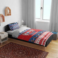 Czech Christmas bedding set on bed featuring red duvet with blue and white festive borders.
