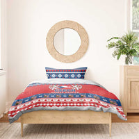 Czech Christmas bedding set on single bed with red duvet cover and blue patterned pillow.