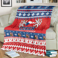 Red, blue, and white Czech Christmas blanket draped over a sofa with decorative borders.