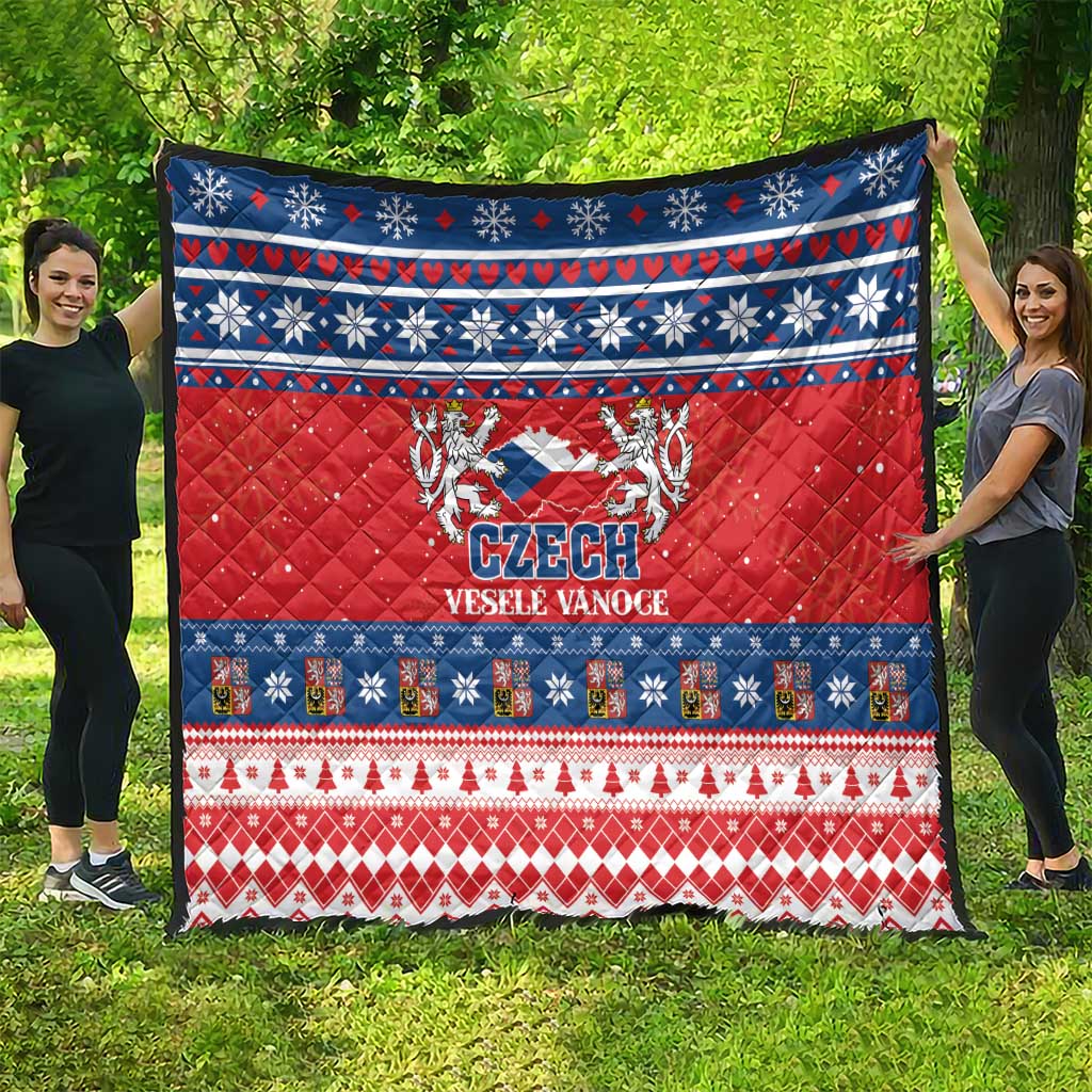 Red Czech Christmas quilt spread outdoors with blue banding, snowflakes, and Czech emblem