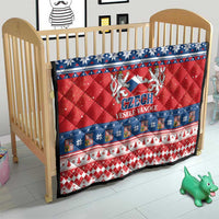 Red Czech Christmas quilt on crib mattress with blue snowflake border and Czech emblem text