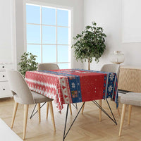 Red Christmas tablecloth with blue and white pattern, draped over dining table