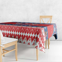 Red Christmas tablecloth with diamond pattern and blue edge on wooden dining table