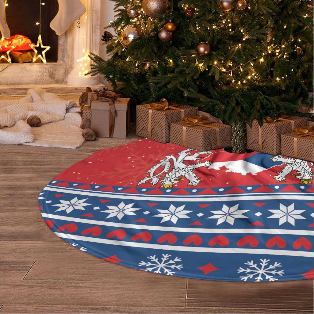 Red and blue Christmas tree skirt lying on floor under a decorated tree