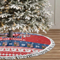 Fringed round Christmas tree skirt with red-and-blue winter pattern under a decorated tree