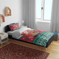 Red and green Christmas duvet with Santa and reindeer, placed on a bed with two pillowcases