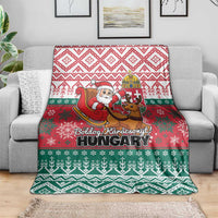 Red and green Hungarian Christmas blanket with Santa sleigh and reindeer graphic on sofa