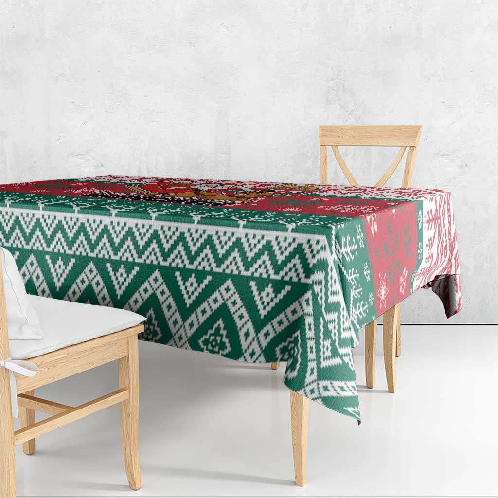 Christmas tablecloth with green and white diamond pattern and a red accent panel on the table.