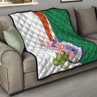 Folded quilt on sofa: green and white halves with orange center stripe and lotus paisley design